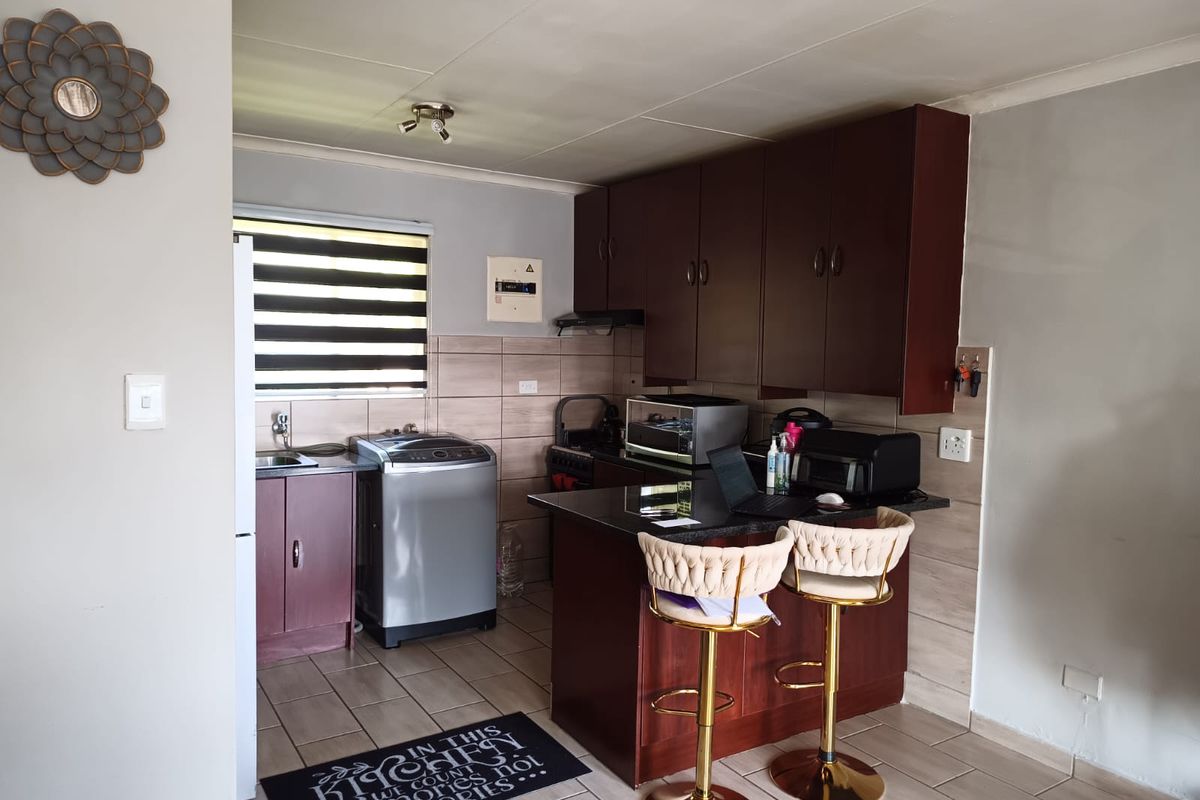 A functional kitchen featuring dark wood cabinetry, granite countertops, tiled backsplash, and integrated appliances, providing a practical workspace for daily cooking and preparation.