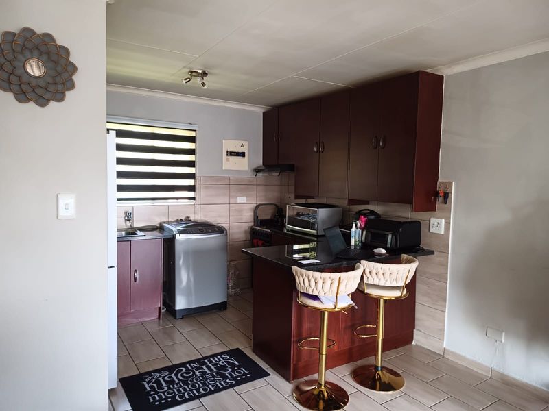 A functional kitchen featuring dark wood cabinetry, granite countertops, tiled backsplash, and integrated appliances, providing a practical workspace for daily cooking and preparation.
