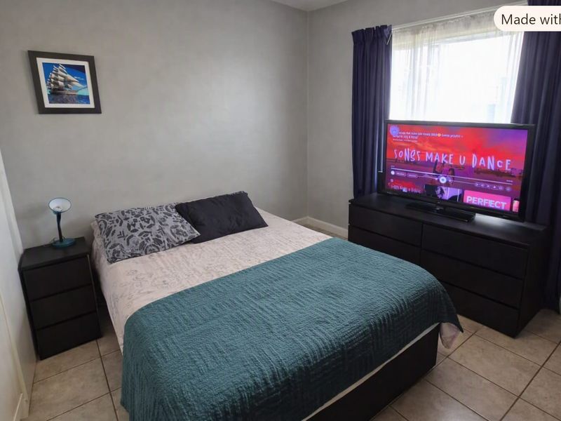 A functional bedroom featuring tiled flooring and a built-in closet, offering a neutral base for personalization.