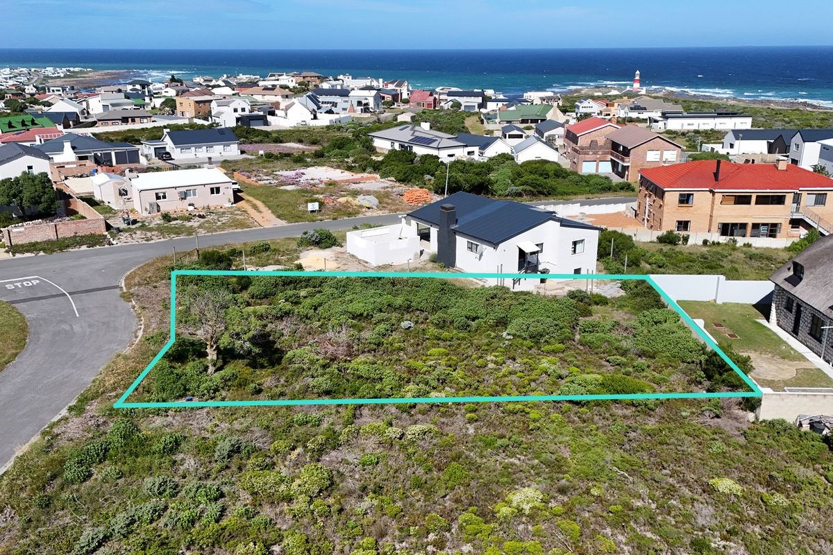 An aerial view of a vacant residential plot in a coastal neighborhood, highlighting the land boundaries and surrounding residential development.