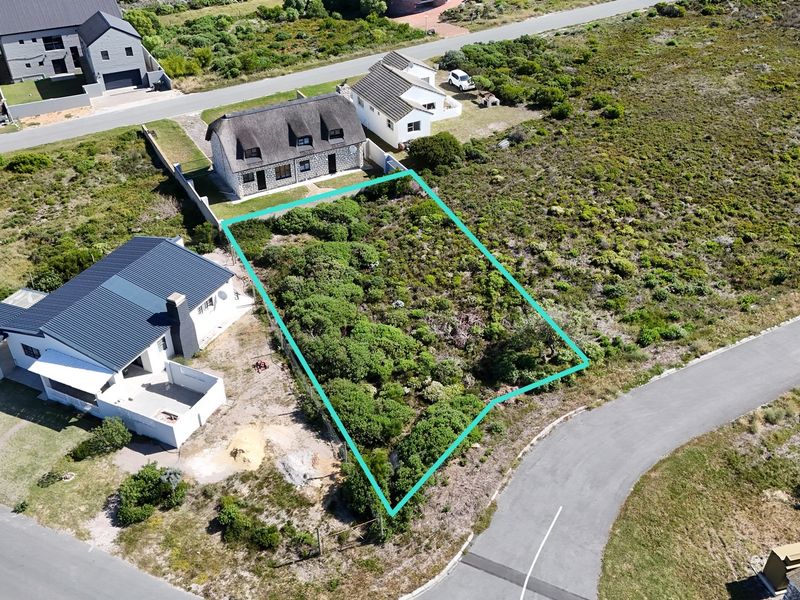 Aerial view of a vacant residential plot in a developed neighborhood, showing the property boundaries and surrounding landscape.