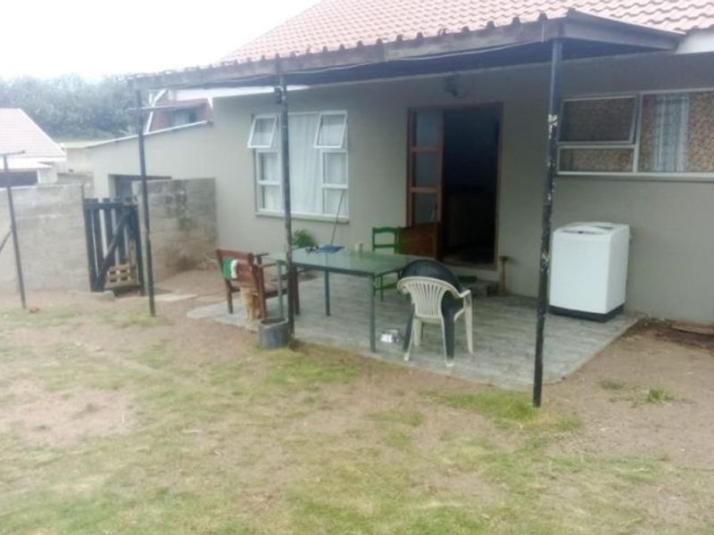 Covered outdoor patio area featuring tiled flooring and metal support structure, providing direct access to the home's rear exterior.