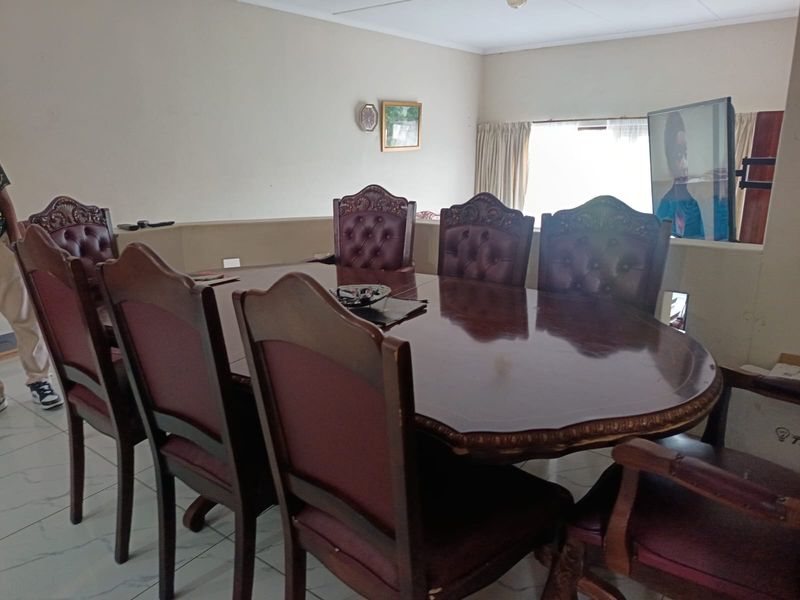 A dining room area featuring tiled flooring and a neutral wall finish, providing a functional space for family meals.