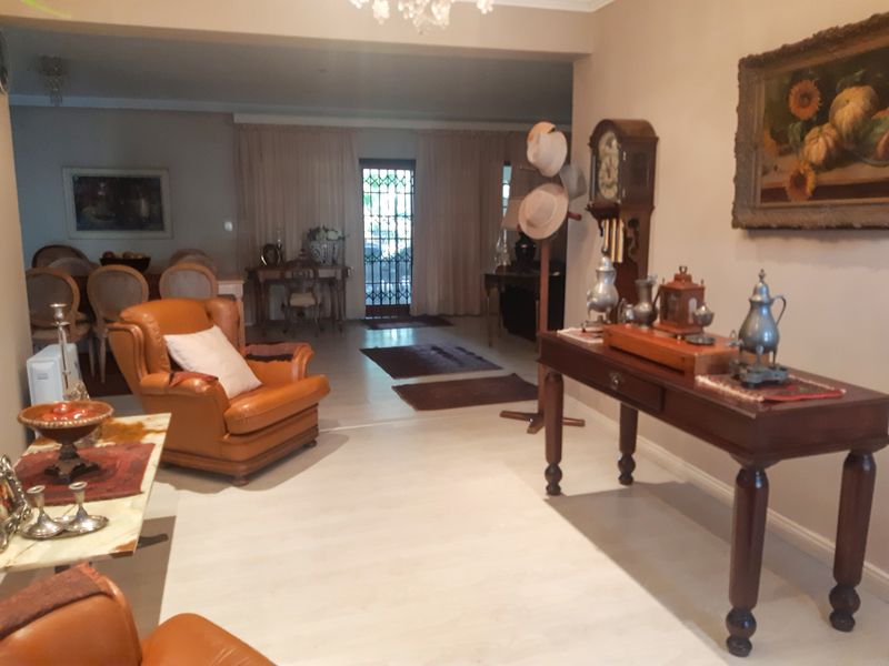 Spacious open-plan living and dining area featuring light-toned laminate flooring and direct access to the exterior through a secure gate.