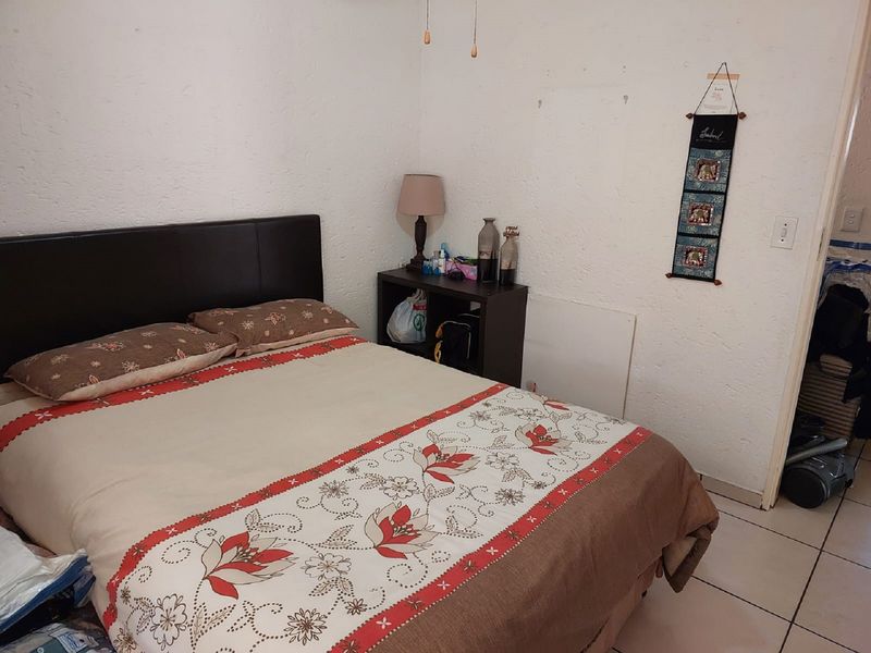 A bedroom featuring tiled flooring and textured walls, offering a functional space ready for cosmetic updates and personalization.