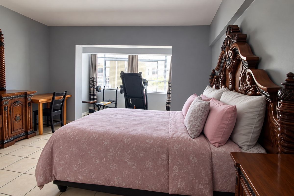 Spacious bedroom featuring tiled flooring and a recessed window area, providing a comfortable and functional living space.