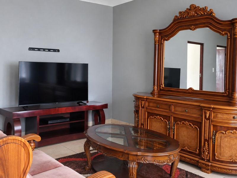 A living room featuring neutral grey walls and tiled flooring, providing a functional space for relaxation and entertainment.
