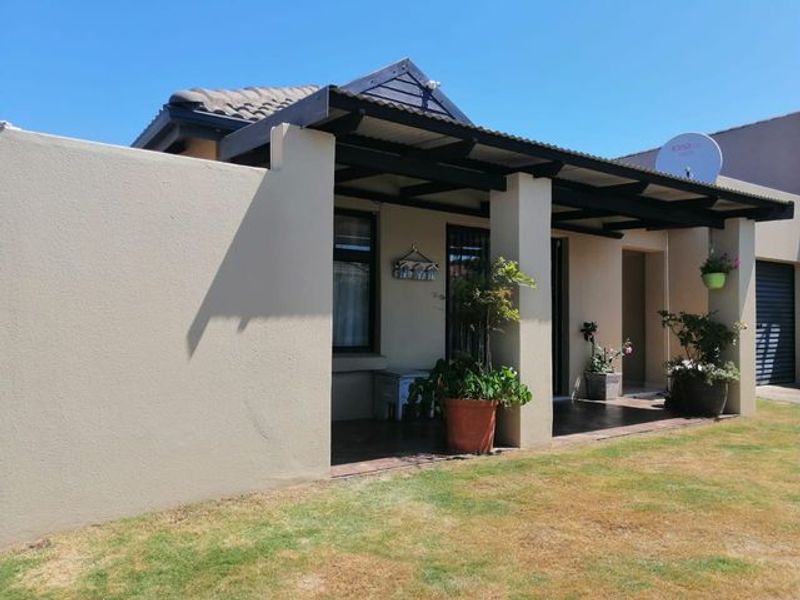 A covered patio area featuring tiled flooring and concrete pillars, providing a sheltered outdoor space adjacent to the main building structure.