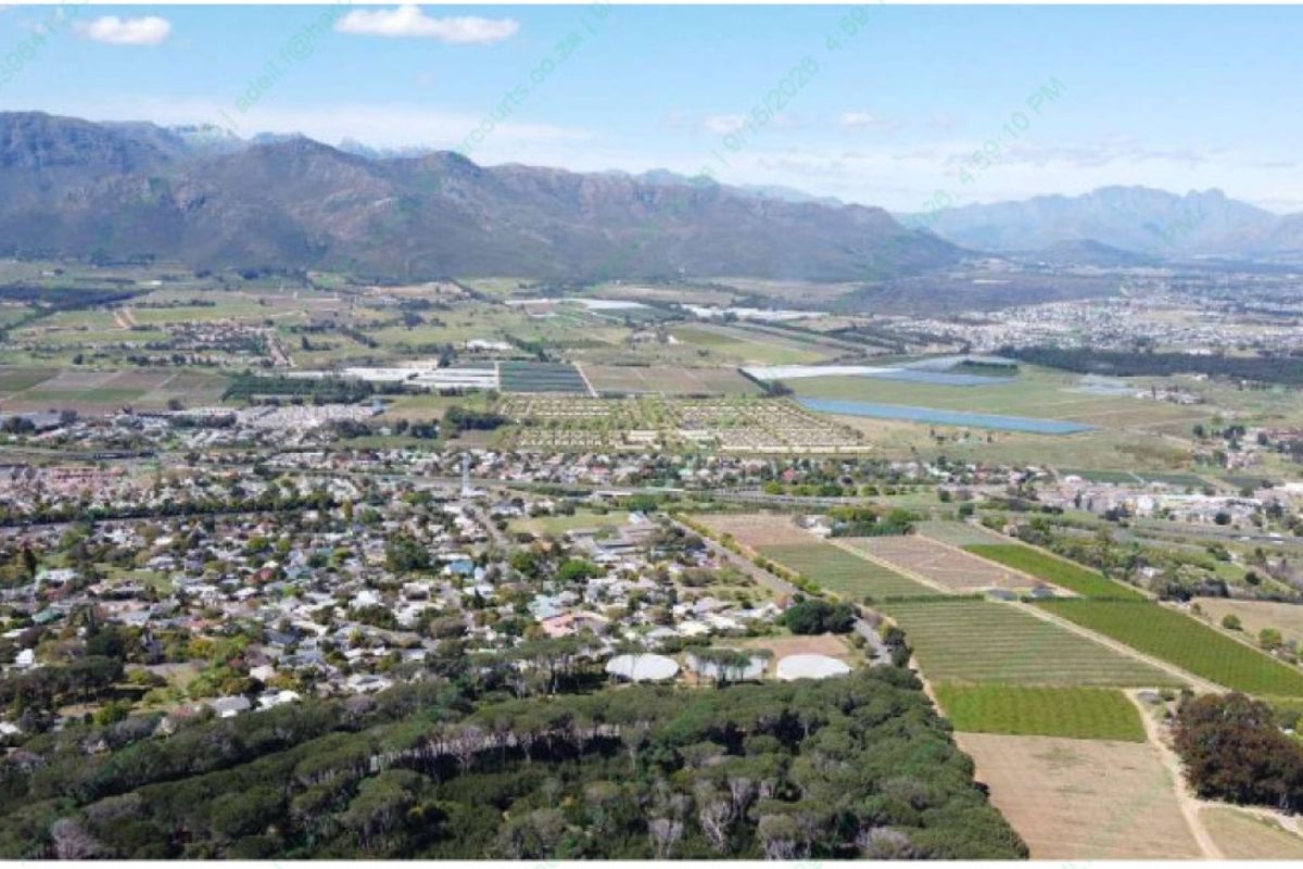 An expansive aerial view of the surrounding landscape, residential area, and mountain range.