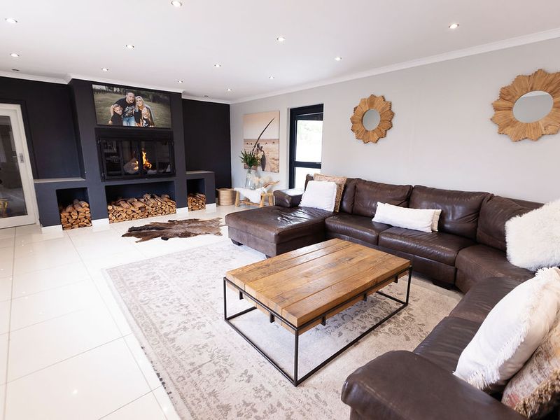 Spacious living room featuring a modern built-in fireplace with integrated log storage, polished tile flooring, and recessed downlighting.