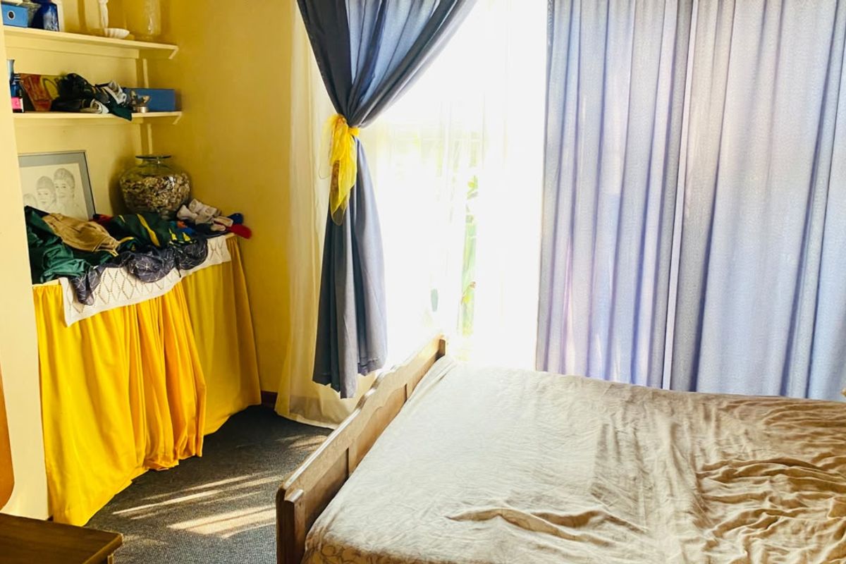 A bedroom featuring carpet flooring, built-in shelving, and a sliding glass door providing natural light.