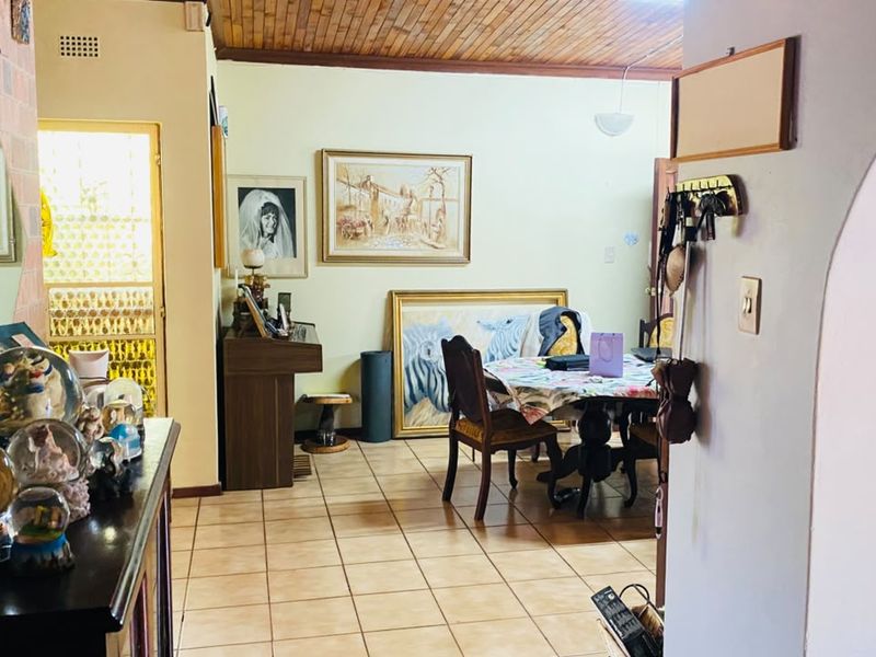 Dining area featuring ceramic floor tiles and a timber tongue and groove ceiling, connected to the rest of the home via an archway.