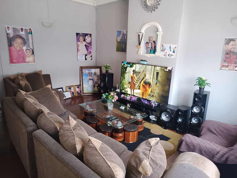 A comfortable living room featuring hardwood flooring and decorative coving, providing a functional space for relaxation and entertainment.