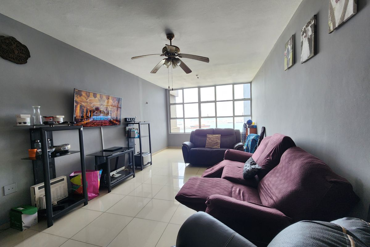 A living room featuring tiled flooring, a ceiling fan, and a large window providing natural light.