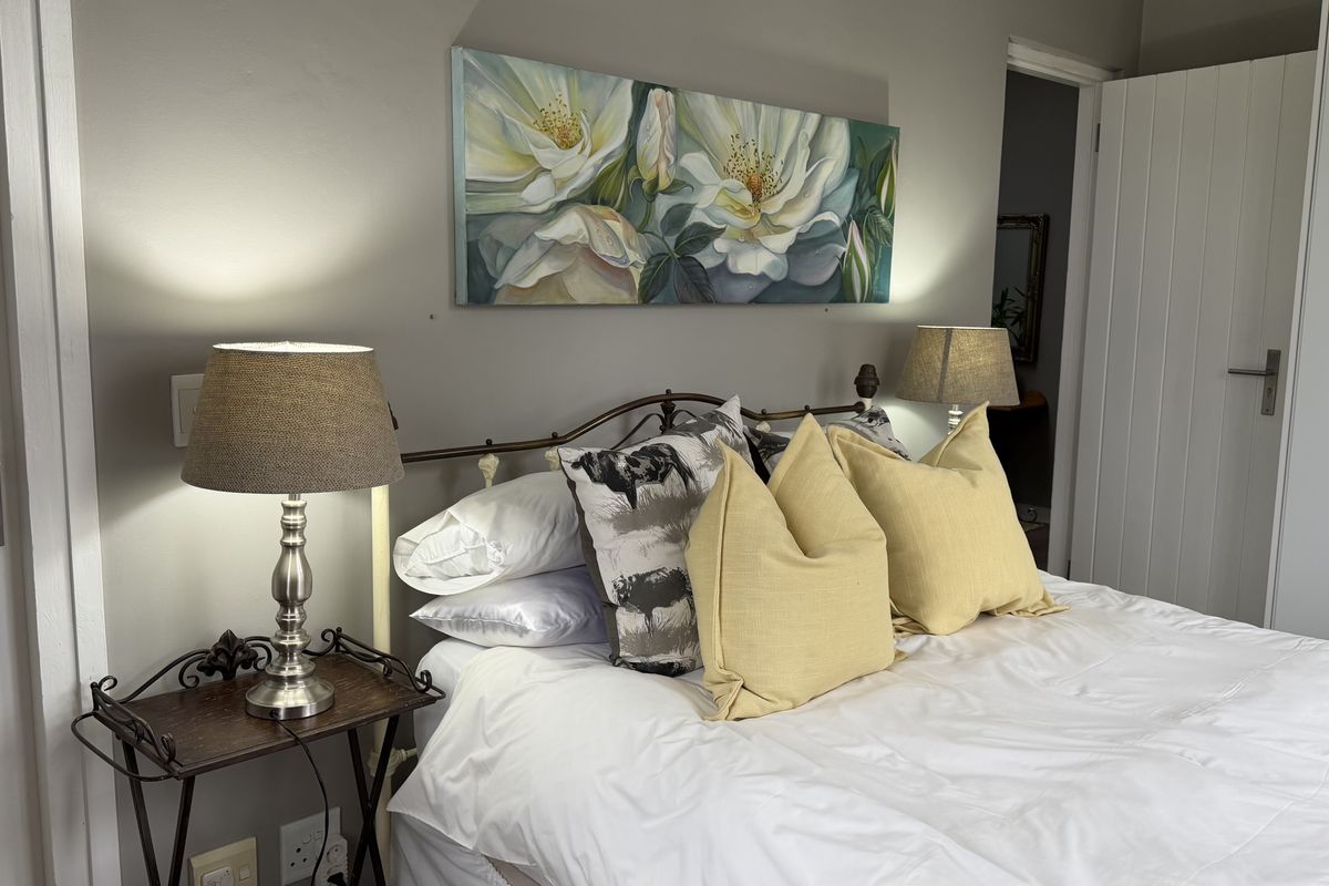 A well-maintained bedroom featuring neutral wall tones, classic door finishes, and integrated electrical fixtures, providing a comfortable and functional living space.