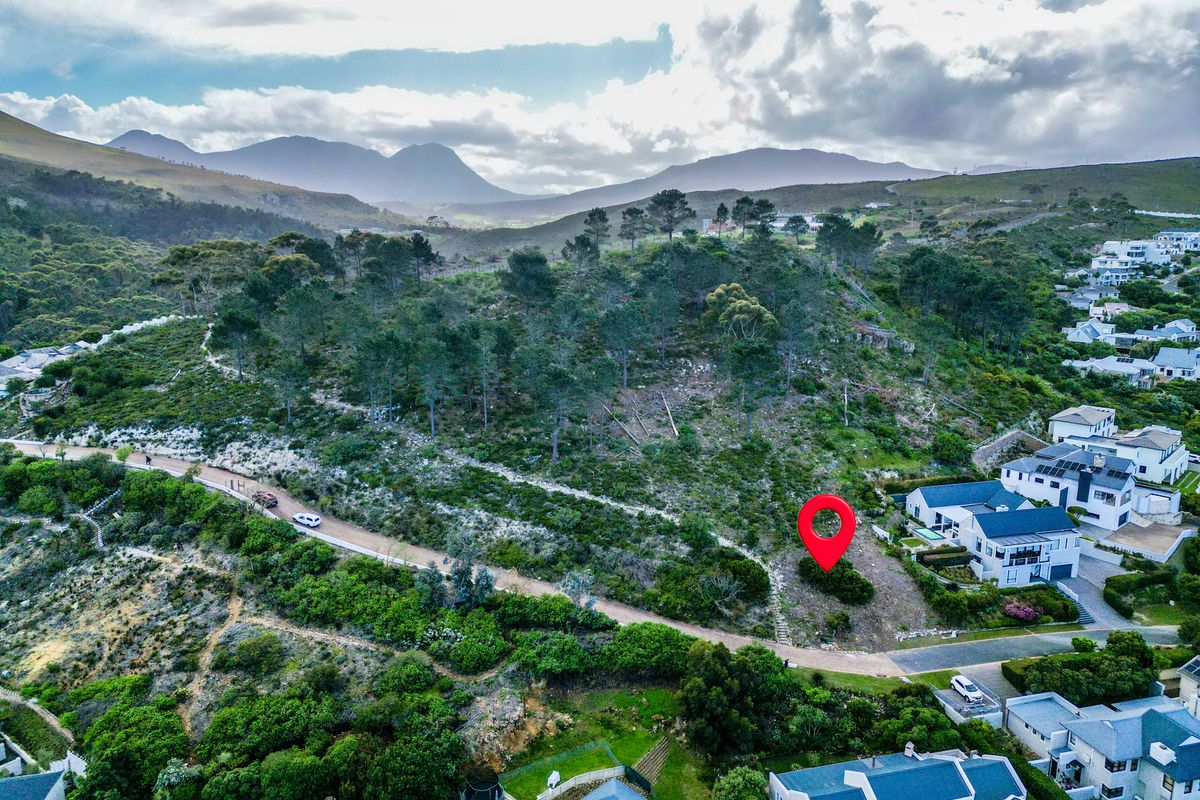 Aerial view of a vacant residential plot featuring sloped terrain and native vegetation, situated in a scenic hillside neighborhood.