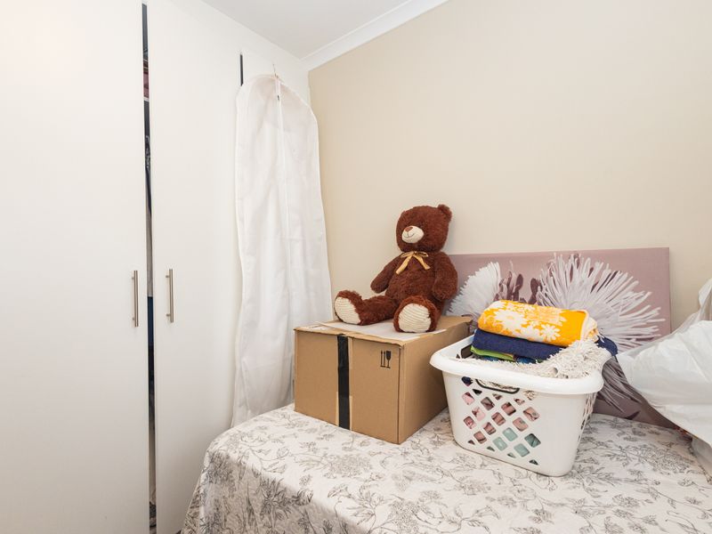 A bedroom featuring a built-in wardrobe with white doors and neutral wall finishes.