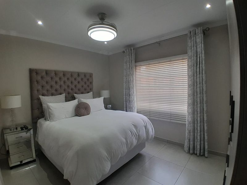 A well-maintained bedroom featuring tiled flooring, recessed lighting, a ceiling fan, and venetian blinds for privacy.