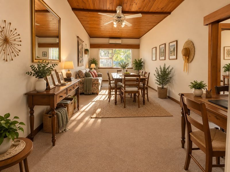 Spacious open-plan living and dining area featuring a warm timber-clad ceiling, ceiling fan, and split-system air conditioning for year-round comfort.