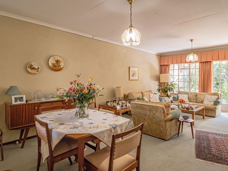 Spacious open-plan living and dining area featuring neutral walls, fitted carpeting, and large sliding glass doors providing access to the garden.