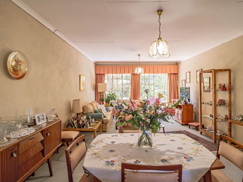 Spacious open-plan living and dining area featuring neutral walls, coved ceilings, and large windows that provide ample natural light.