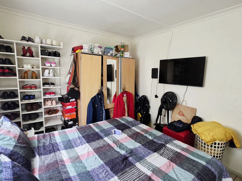 A bedroom featuring built-in shelving units and coved ceiling detailing, providing functional storage space within the room.