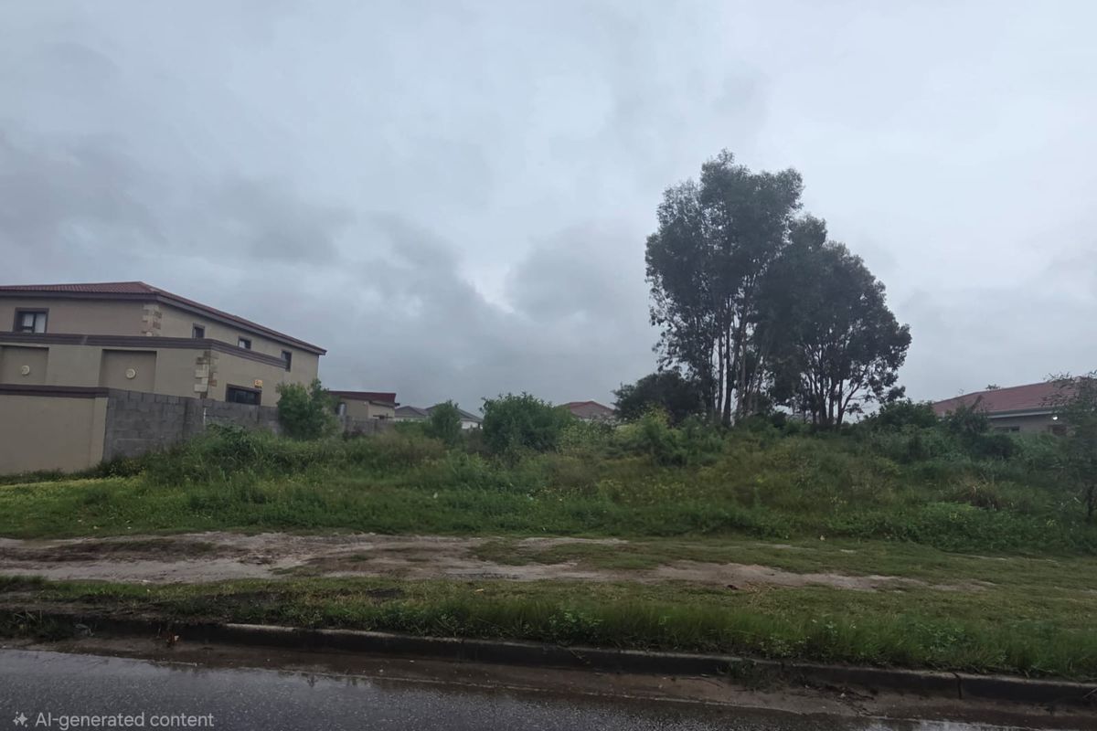 A vacant residential plot featuring established trees and boundary walls, situated in a developed neighborhood.