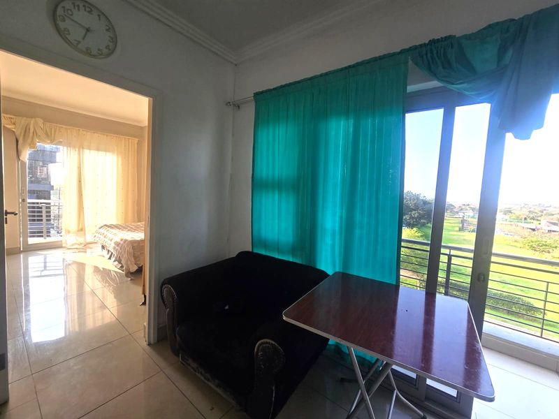Living area featuring tiled flooring and a sliding glass door providing access to a balcony with outdoor views.