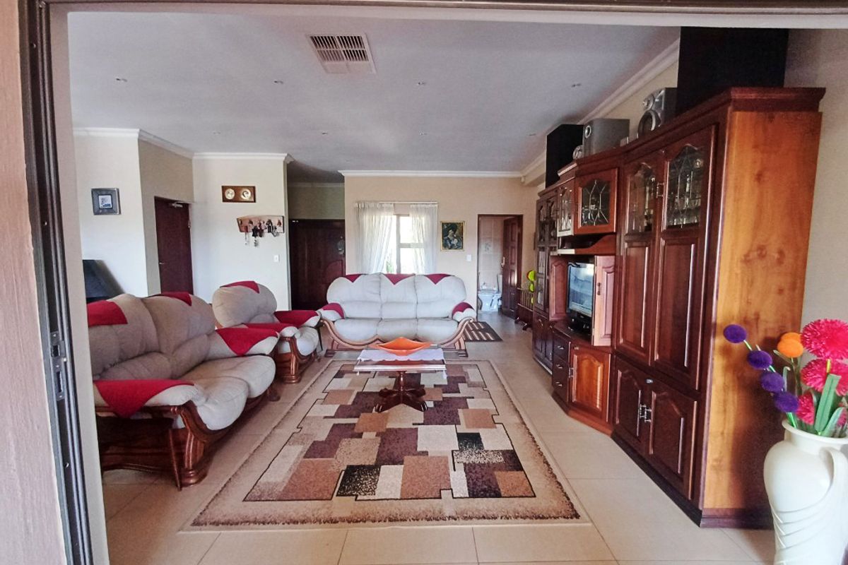 Spacious living room featuring tiled flooring, recessed downlighting, and coved cornicing, offering a comfortable and functional layout for family relaxation.