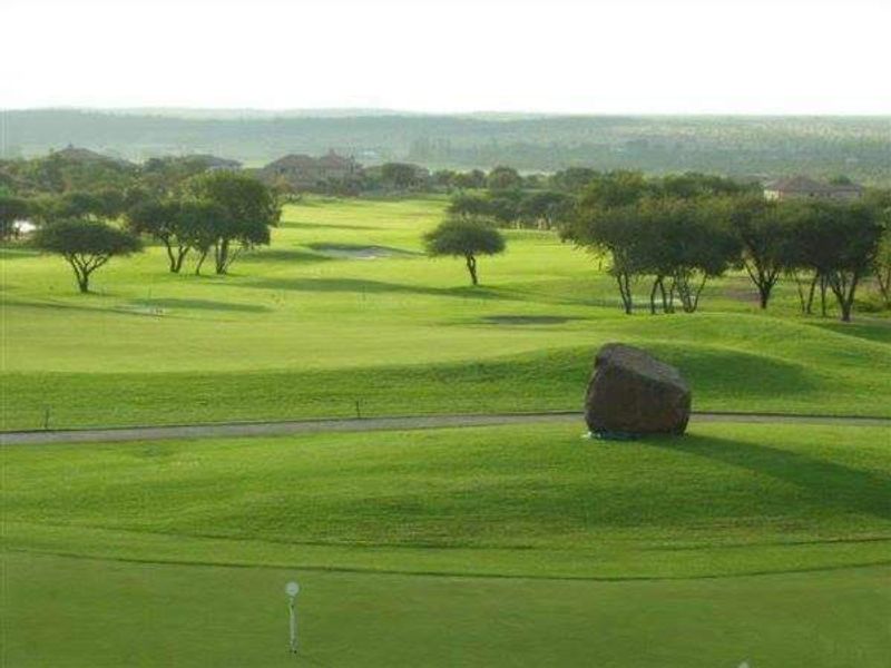 A scenic view overlooking a well-maintained golf course with lush green fairways and mature trees.