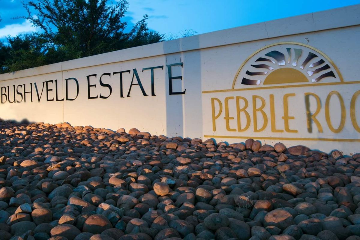 Entrance signage for Pebble Rock Golf & Bushveld Estate, featuring a well-maintained boundary wall and decorative rock landscaping.