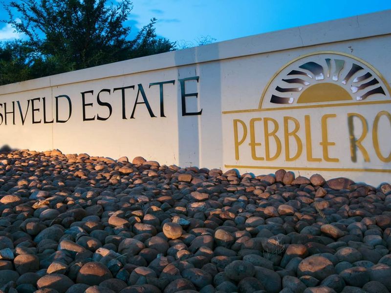 Entrance signage for Pebble Rock Golf & Bushveld Estate, featuring a well-maintained boundary wall and decorative rock landscaping.