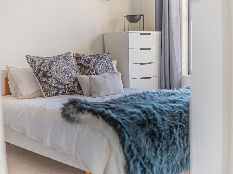 A well-lit bedroom featuring neutral wall finishes and tiled flooring, providing a comfortable and functional living space.