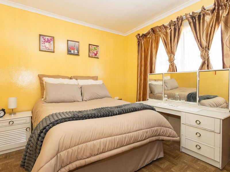 A bedroom featuring parquet flooring and coving, providing a functional space with potential for modern updates.