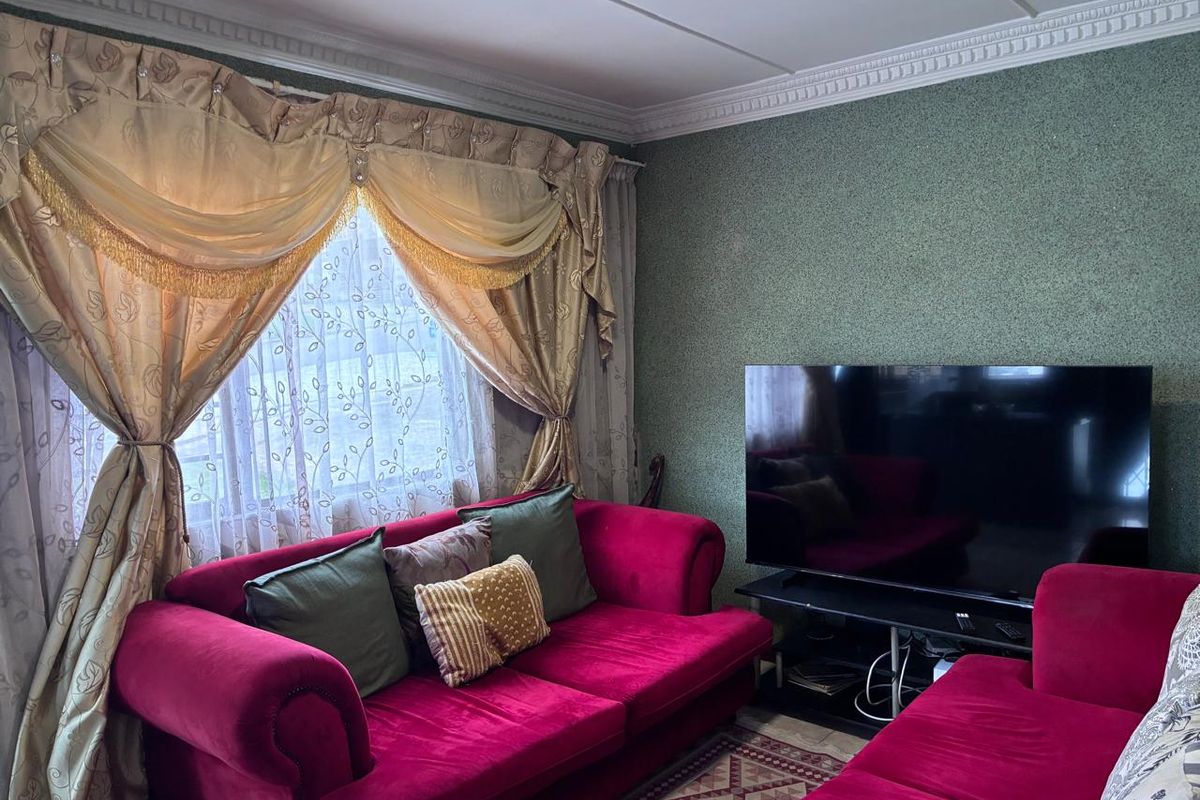 A living room featuring decorative ceiling cornicing and textured wall finishes, providing a traditional foundation for updated interior styling.