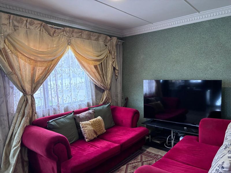 A living room featuring decorative ceiling cornicing and textured wall finishes, providing a traditional foundation for updated interior styling.