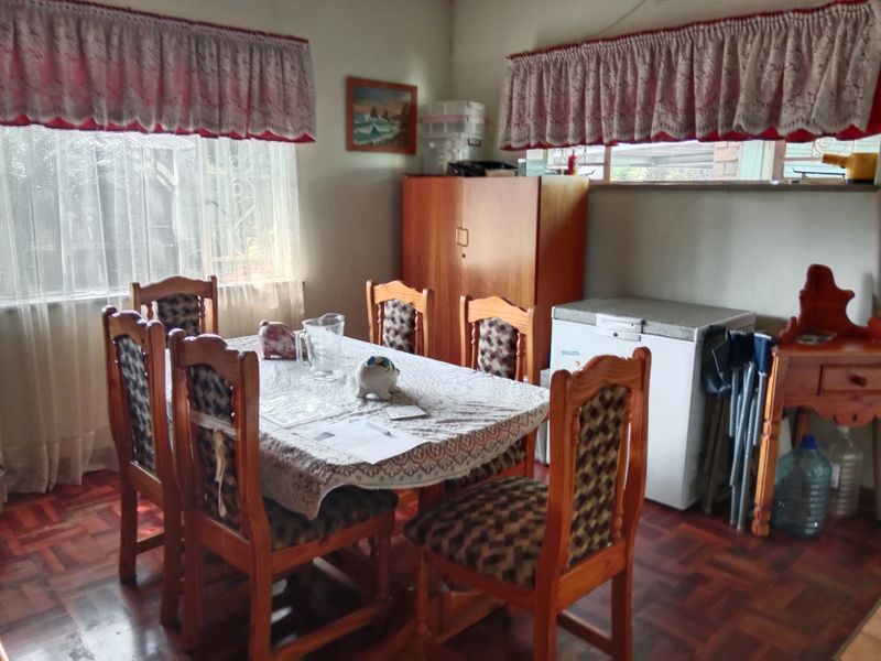 A dining room featuring traditional parquet flooring and a built-in storage cupboard, offering a functional space for family meals.