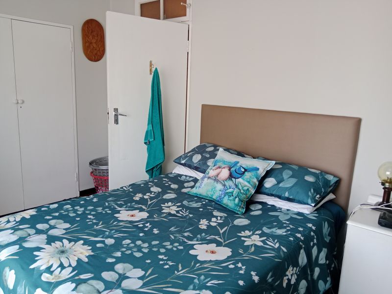 A functional bedroom featuring a built-in wardrobe and neutral wall finishes, providing a comfortable and practical living space.