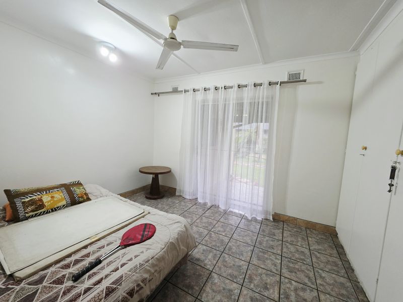 A bedroom featuring tiled flooring, a ceiling fan, and a sliding glass door providing access to the exterior.