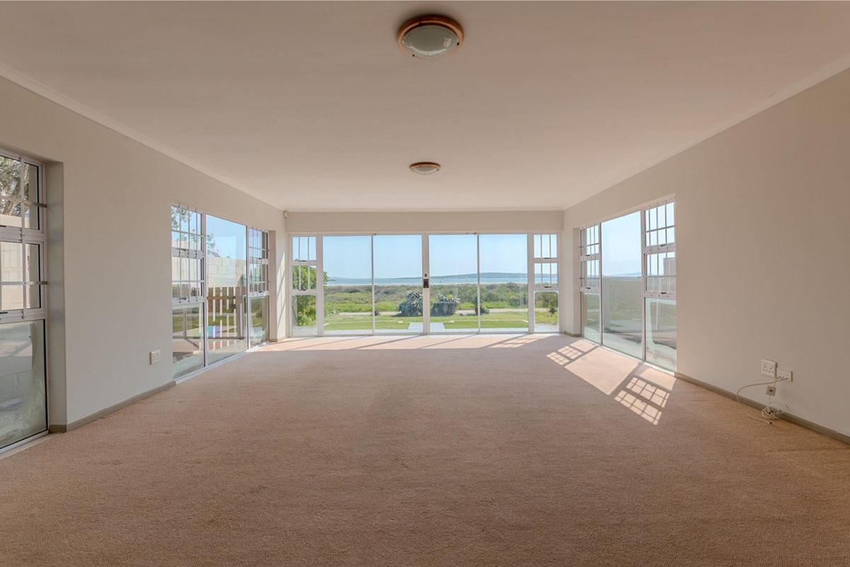 Spacious, light-filled living area featuring expansive sliding glass doors that offer panoramic views and direct access to the outdoors.