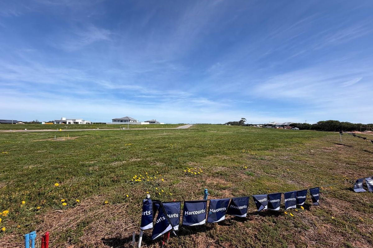 A wide-angle view of a vacant residential plot featuring clear survey markers and utility connection points, ready for development.