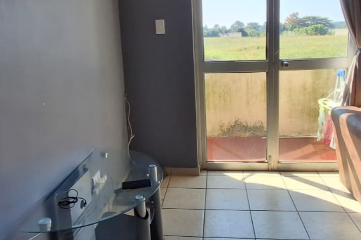 Living room featuring tiled flooring and a sliding glass door providing access to an outdoor balcony area.