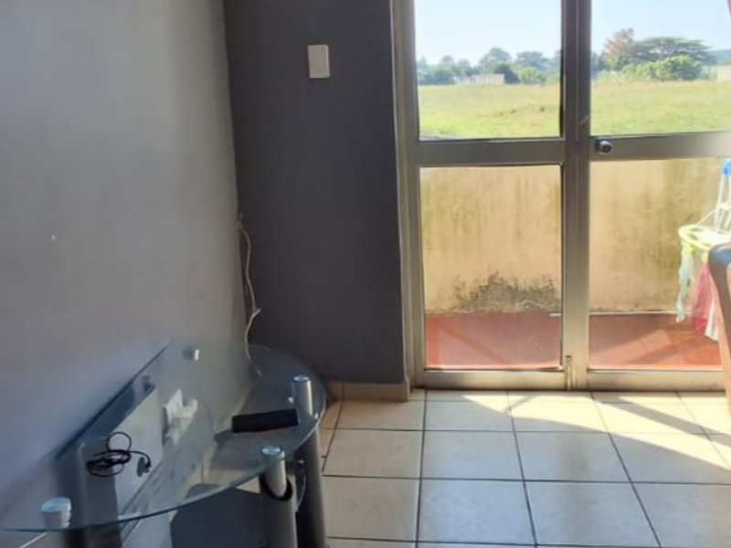 Living room featuring tiled flooring and a sliding glass door providing access to an outdoor balcony area.
