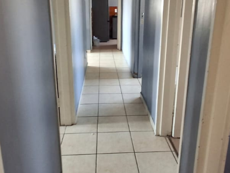 A functional hallway featuring tiled flooring and multiple doorways, providing access to various rooms within the apartment.