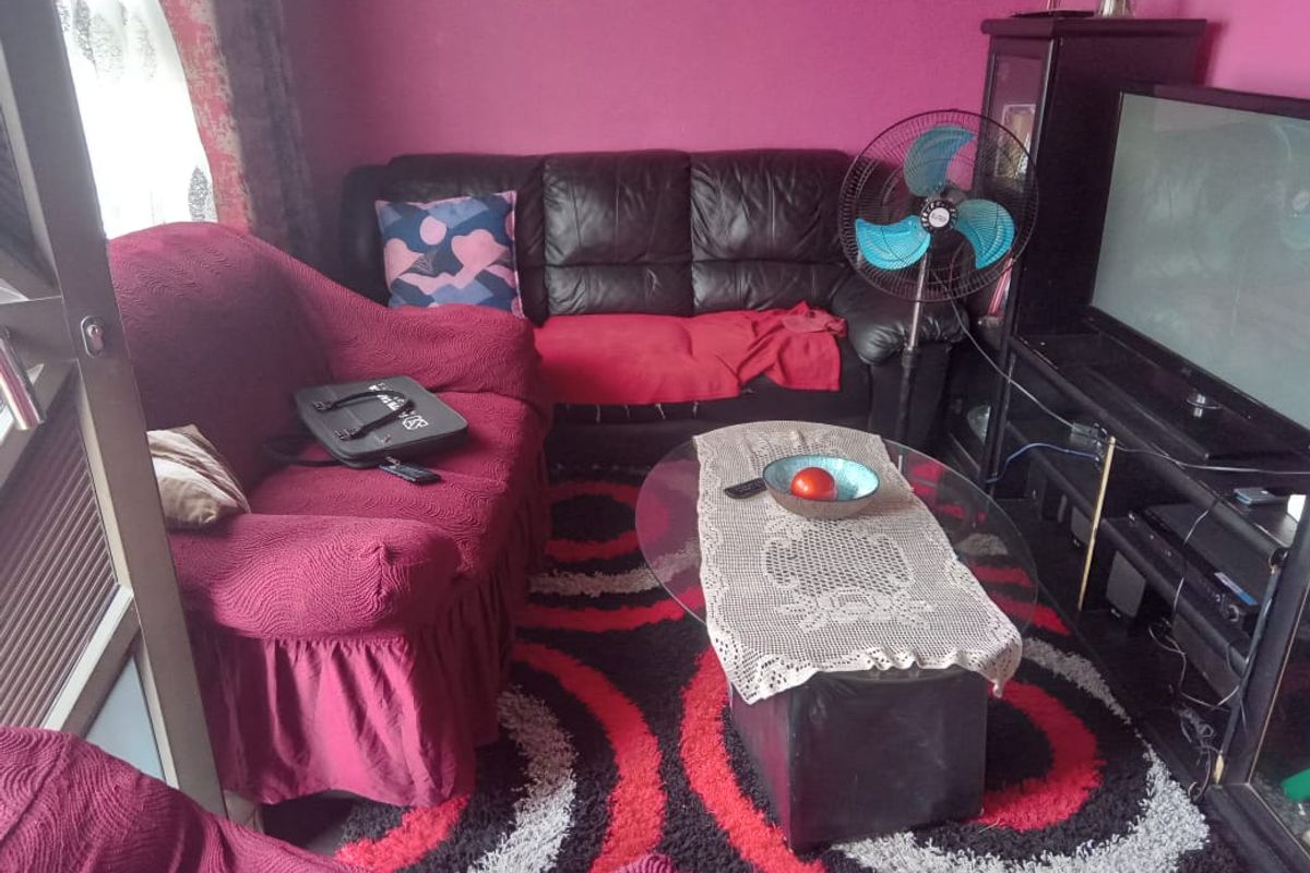A compact living room area featuring a sliding door and bold wall color, providing a functional space for relaxation.