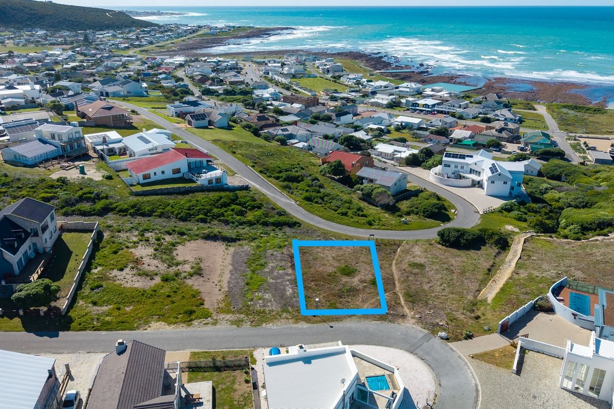 An aerial view of a vacant residential plot situated in a coastal neighborhood, highlighting its location and proximity to the ocean.