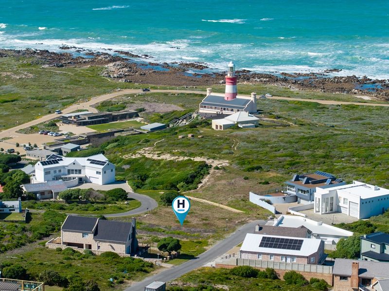 Aerial view of a vacant residential plot situated in a coastal neighborhood near the lighthouse, offering prime development potential.