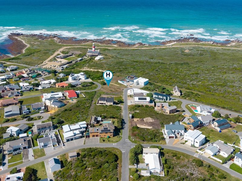 Aerial view of a vacant residential plot situated in a coastal neighborhood near the lighthouse, offering prime development potential.