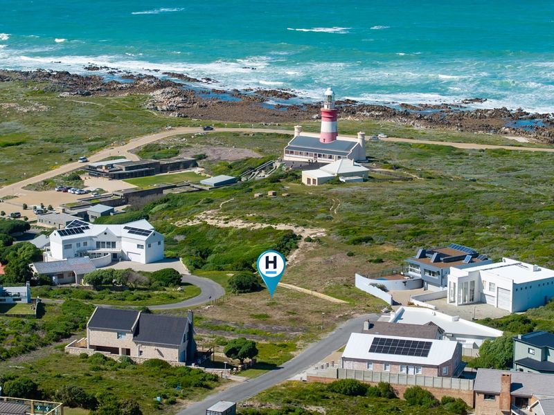 Aerial view of a vacant residential plot situated in a coastal area near the lighthouse, offering prime development potential.