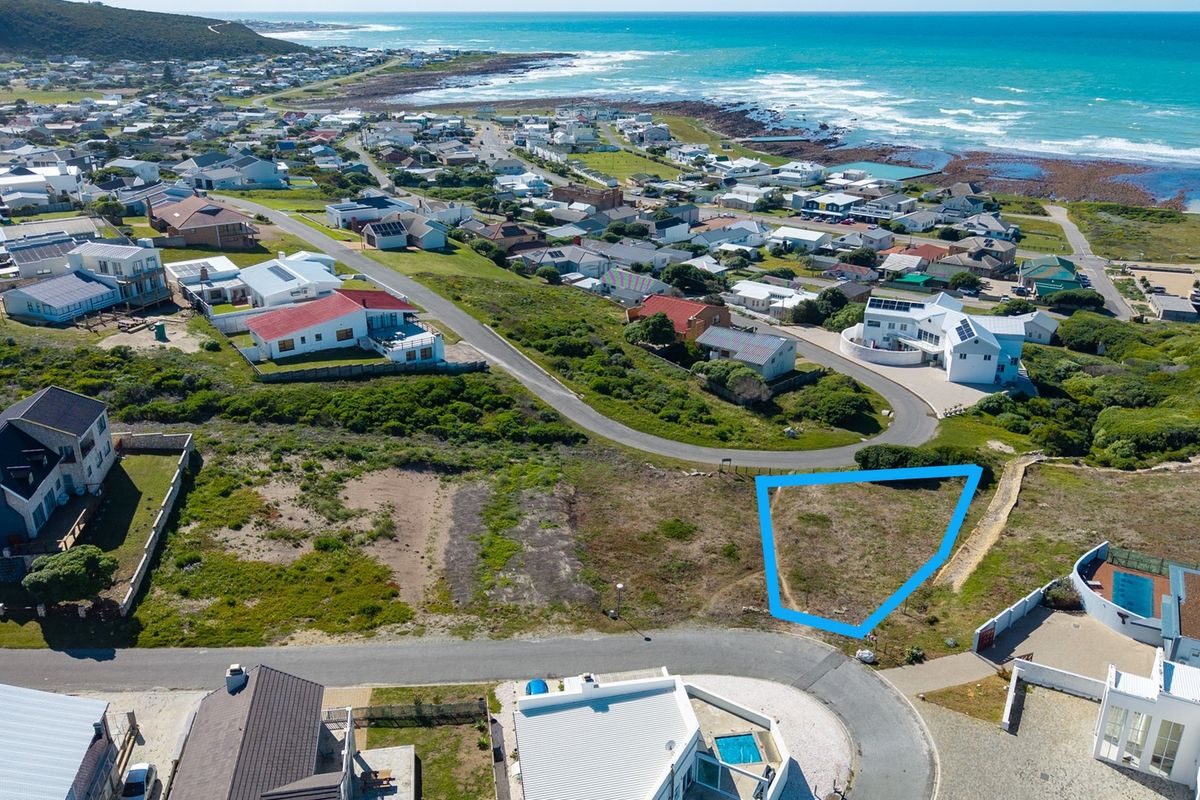 An aerial view of a vacant residential plot situated in a coastal neighborhood, highlighting its location and proximity to the ocean.